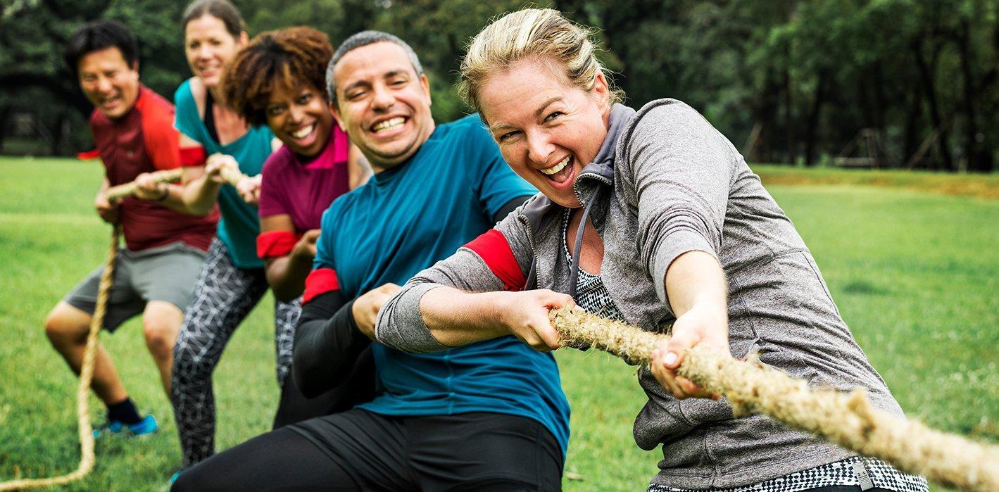 A team of individuals engaged in a tug-of-war, emphasizing collaboration and strength through their joint effort.